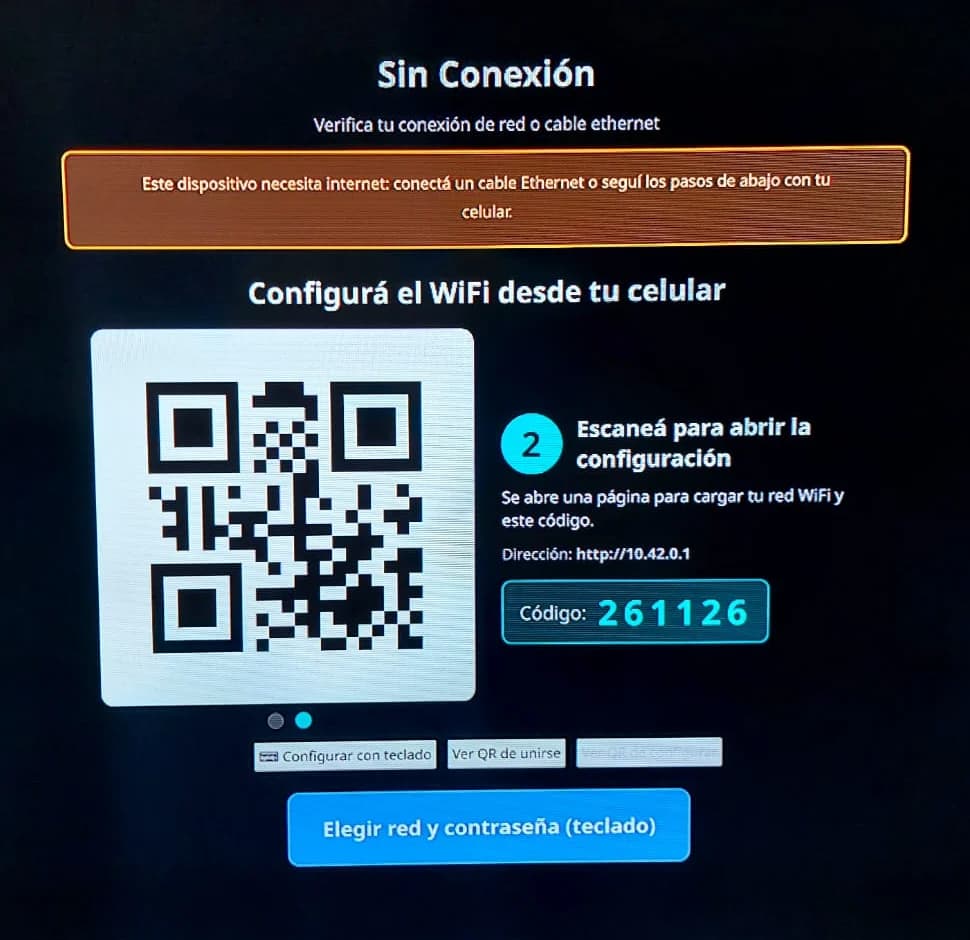 Foto de la misma pantalla mostrando el paso 2: el código QR que abre la página de configuración en el celular, la dirección 10.42.0.1 y el código de seis dígitos